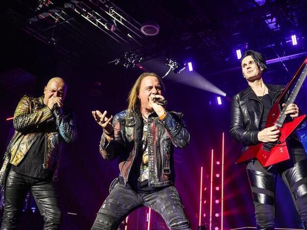 Helloween performing live under dramatic purple stage lighting