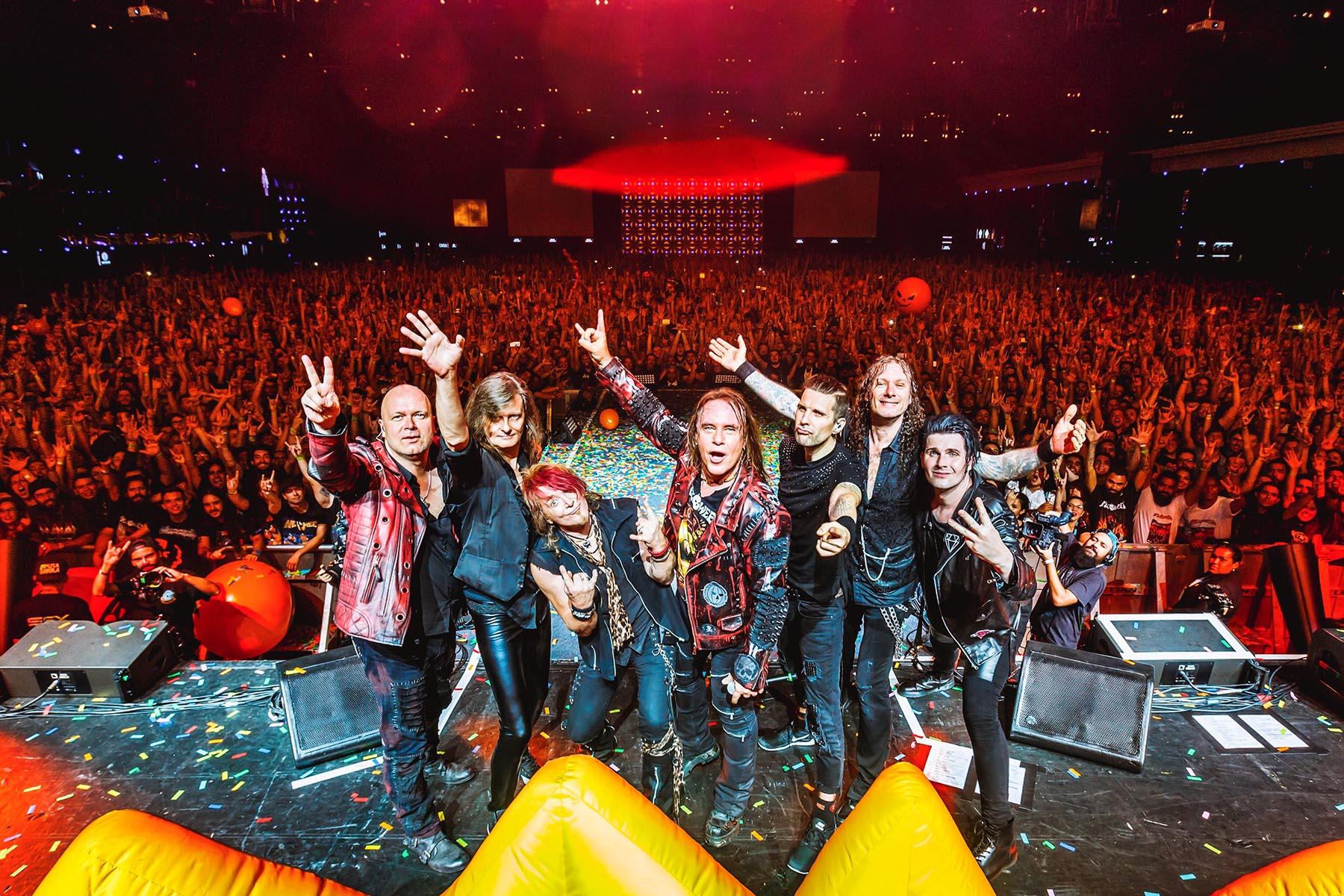 Helloween's reunited lineup celebrating on stage in front of a huge concert crowd